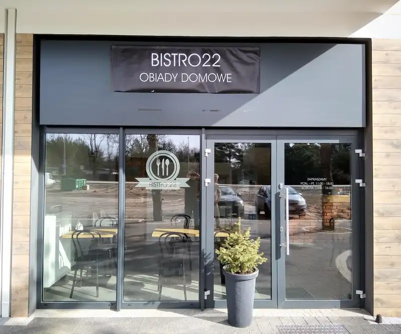 Wejście do Bistro 22 z czarnym szyldem Obiady domowe
